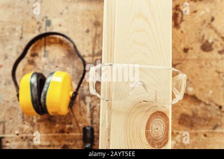 Schutzkopfhörer und -Brille in Schreinerei, Bauwerkzeugen und Gerätekonzept Stockfoto