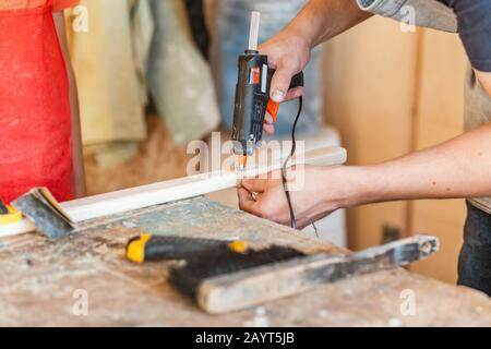 Tischler, der in der Werkstatt mit Klebstoff für Holz arbeitet Stockfoto