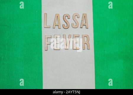 Nigerianische Flagge unter den Worten Lassa Fever Outbreak-Konzept. Atemschutzmaske und Spritze. Lassa hämorrhagisches Fieber LHF endemisch in Westafrika inkl Stockfoto