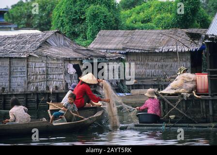 Menschen, die im schwimmenden Dorf am Tonle Sap Lake bei Siem Reap in Kambodscha an einem Fischernetz arbeiten. Stockfoto