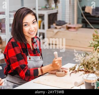 Junge Frauenfreunde schaffen in der Töpferwerkstatt Ton- und Keramikkunstgerichte Stockfoto