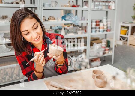 Junge Frauenfreunde schaffen in der Töpferwerkstatt Ton- und Keramikkunstgerichte Stockfoto