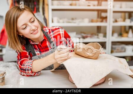 Junge Frauenfreunde schaffen in der Töpferwerkstatt Ton- und Keramikkunstgerichte Stockfoto