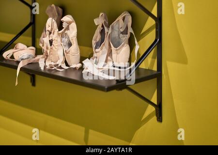 Point-Schuhe mit Bändern auf dunklem Regal Stockfoto