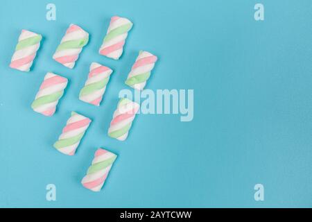 Marshmallows in Pastellfarben diagonal auf hellblauem Hintergrund mit Kopierraum angeordnet Stockfoto
