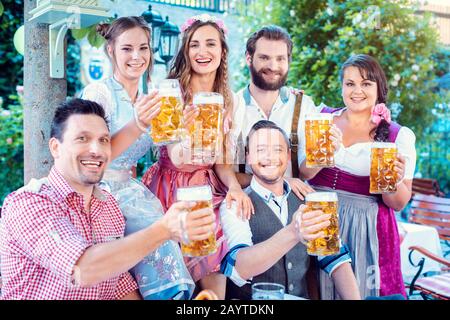 Eine Gruppe fröhliche Leute, die Bier trinken und in die Kamera schauen Stockfoto