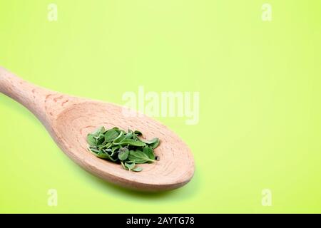 Holzlöffel mit Minzblättern über grünem Hintergrund Stockfoto