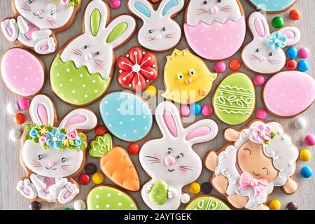 Buntes, leckeres Lebkuchen in unterschiedlicher Form und Größe für die Osterfeier. Hausgemachte süße Dekoration über Holzhintergrund. Traditionelle Zeichen und Symbole. Stockfoto