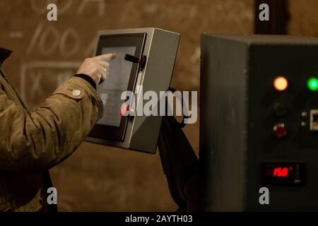 Arbeiter, der das Armaturenbrett von CNC-Maschinen oder die Steuerung an der Maschine im Werk verwendet. Industrie- und Fertigungskonzept Stockfoto
