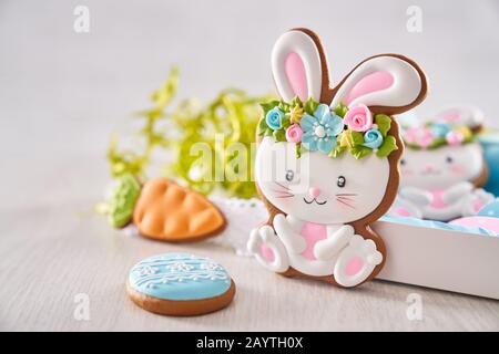 Osterhase und Eier süße Plätzchen mit bunter Glasur über hellem Holzhintergrund. Handgefertigte Lebkuchen für festliche Feierlichkeiten. Vorbereitungskonzept. Stockfoto