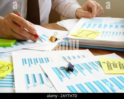 Unternehmer, die mit Geschäftsberichten arbeiten und Finanzdaten prüfen. Unterlagen im Büro. Stockfoto