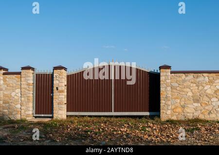 Exquisiter Steinzaun vor dem Hintergrund eines Sommergartens Stockfoto