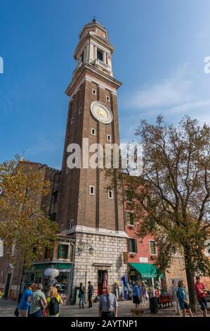 Venedig, Italien - 27. September 2013: Wahrzeichen von Venedig, der Turm Santi Apostoli mit Uhr und Menschenmenge auf der Straße Stockfoto