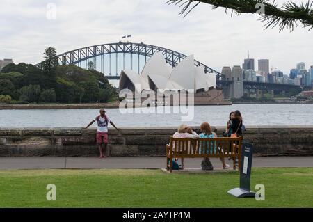 Sydney, Australien - 10. Oktober 2014: Menschen im Royal Botanic Garden von Sydney mit Sydney Opera House und Sydney Harbour Bridge im Hintergrund Stockfoto