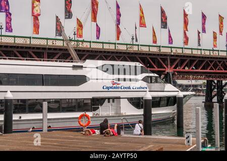 Sydney, Australien - 10. Oktober 2014: Kapitän Cook Kreuzfahrtschiff im Darling Harbour mit Menschen, die sich am Wasser entspannen Stockfoto