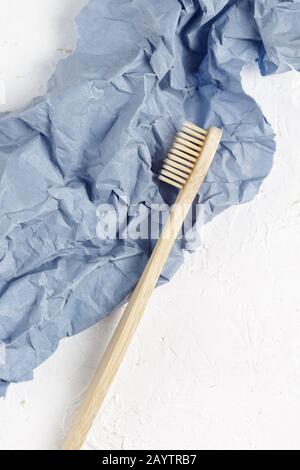 Nahaufnahme der Bambuszahnbürste auf einem weißen und violetten Papierhintergrund. Umweltfreundliche Produkte, Null-Abfall-Konzept Stockfoto