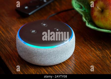 Bath, Großbritannien - 17. FEBRUAR 2020: Nahaufnahme eines Amazon Echo Dot der 3. Generation, das blau auf einem Tisch in einem heimischen Umfeld leuchtet Stockfoto