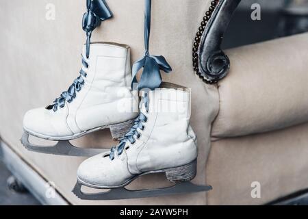 Foto des Paares getragen Winterleder weiße Schlittschuhe zum Eiskunstlaufen mit Schnürsenkeln hängen am Band. Gebrauchte Skates von Profi-Skatern oder Eis-Hoc für Damen Stockfoto