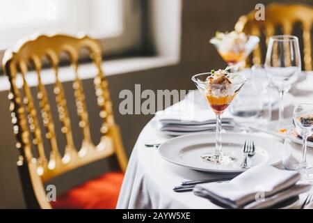 Schön dekorierter Esstisch mit luxuriösem Besteck, Holzstuhl, köstlichem alkoholfreiem Getränk oder Cocktail. Festlich serviert Tisch für spezielle Occa Stockfoto