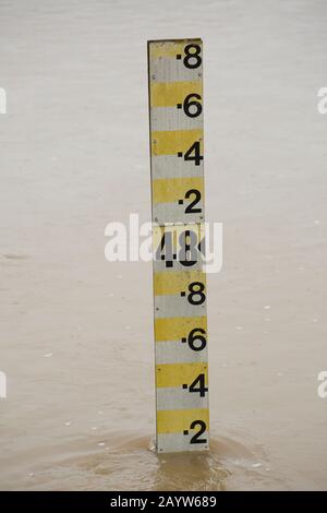 Ein Wasserstandsmarker im Flooding River Stour in der Nähe von Sturminster Newton, der nach starken Regenfällen von Storm Dennis mit Wasser geschwollen ist. Das Stor Stockfoto