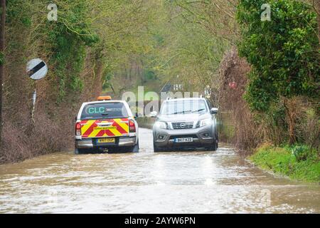 Autos, die während des Sturms Dennis auf einer überfluteten Straße fahren. Much Hadham, Hertfordshire. GROSSBRITANNIEN Stockfoto