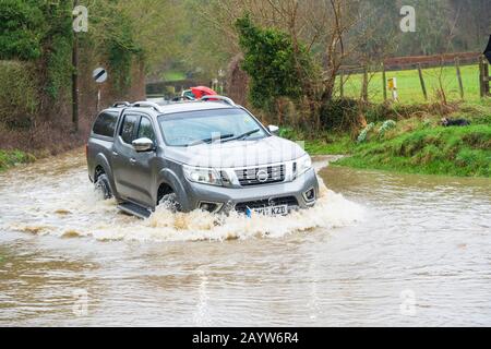 Auto fährt durch einen überfluteten ford in Much Hadham, Hertfordshire. GROSSBRITANNIEN Stockfoto