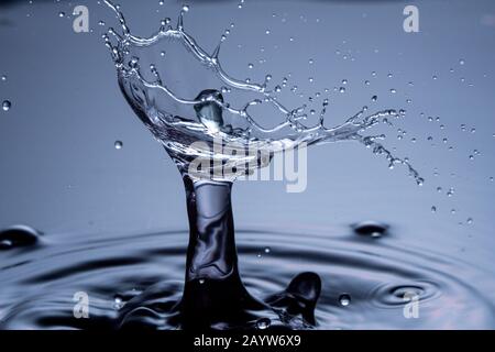 Wassertropfen Zusammenstoß auf einem blauen Hintergrund. Abstrakte klare Natur Hintergrund Stockfoto