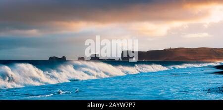 Wunderschöne Panoramalandschaft mit großen Wellen am Schwarzen Strand. Stürmische Wellen des Atlantiks und eine Wolkenlandschaft. Reynisdrangar, Vik, Island Stockfoto