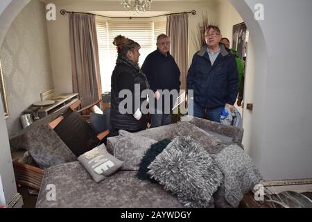 Der walisische Erste Minister Mark Drakeford (Zentrum) und Mitglied der walisischen Versammlung für Pontypridd, Mick Antoniw (rechts), mit der in ihrem Haus in der Oxford Street, Nantgarw, in Südwales ansässigen Caroline Jones, die Hochwasserschäden inspizieren, Wo die Bewohner in ihre Häuser zurückkehren, um die Schäden nach dem Sturm Dennis zu untersuchen und zu beheben. Stockfoto