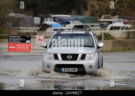 Ein Auto passiert eine überflutete Straße, während das Wasser in der Nähe von Yalding in Kent nach dem Sturm Dennis steigt, der schwere Regenfälle und Überschwemmungen in Teile Großbritanniens mit sich bringt. Stockfoto