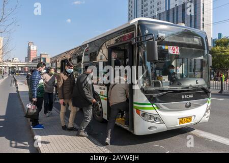 Shanghai, China. Februar 2020. Maskierte Passagiere steigen an einem Busbahnhof in Shanghai, Ostchina, 17. Februar 2020 in einen Bus. Die Behörden in Shanghai ordneten am Montag an, dass Bus- und Taxifahrer Gesichtsmasken tragen, um die Verbreitung des neuartigen Coronavirus zu kontrollieren. Passagiere, die keine Masken tragen, dürfen ab Montag keine Busse und Taxis mitnehmen, sagte das städtische Straßenverkehrsamt. Fahrer müssen außerdem Gesichtsmasken tragen. Credit: Wang Xiang/Xinhua/Alamy Live News Stockfoto