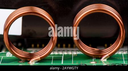 Elektronische Bauteile. Induktivitäten werden auf die Elektronikplatine gelötet. Nahaufnahme. Stockfoto
