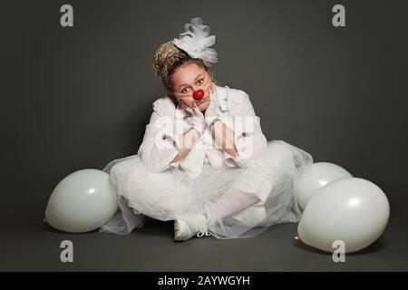 Weiße Clownfrau auf grauem Hintergrund, Studio-Porträt Stockfoto