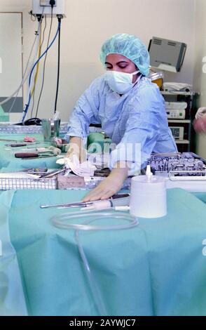 Eine Scheuerschwester, die die sterilen chirurgischen Instrumente vorbereitet Stockfoto