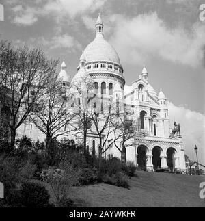 In den 1950er Jahren hatte man einen historischen Blick auf das pariser Wahrzeichen von Sacre-Coeur, Paris, Frankreich, eine kuppelkirche, die im Jahre 1919 eingeweiht wurde und eines der unkonischen Denkmäler der französischen Stadt, die auf einem Hügel im Bezirk Montmartre liegt. Stockfoto