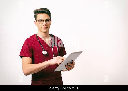 Konzept für das Gesundheitswesen und die Medizin - junger männlicher Arzt mit Stethoskop und Tablette in den Händen Stockfoto