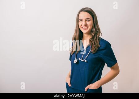 Fröhliche junge Frau Doktor mit Stethoskop über Hals an Kamera isoliert auf weißem suchen Stockfoto