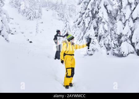 Mann und Frau Reisende in einem Winterwald nehmen vor dem Hintergrund einer verschneiten Landschaft ein selfie Stockfoto