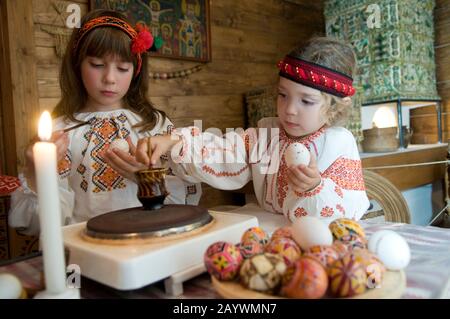 Kolomyia, Oblast Ivano-Frankiwsk/Ukraine - 10.07.2008. In ukrainische Volkstrachten gekleidete Schwestern malen zu Ostern Eier. Stockfoto