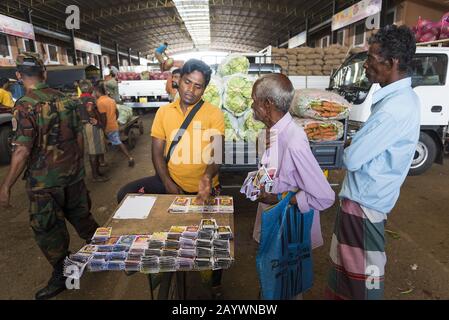 Dambulla, Sri Lanka: 18.03.2019: Im Obst- und Gemüsemarkt. Männer, die Lotterietickets verkaufen. Stockfoto