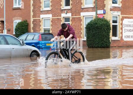 Hereford, Herefordshire, Großbritannien - Montag, 17. Februar 2020 - EIN junger Teenager hat Spaß beim Fahrradfahren durch das überschwemmte Gebiet der Ledbury Road der Stadt. Foto Steven May / Alamy Live News Stockfoto