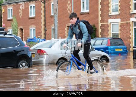 Hereford, Herefordshire, Großbritannien - Montag, 17. Februar 2020 - EIN junger Teenager hat Spaß beim Fahrradfahren durch das überschwemmte Gebiet der Ledbury Road der Stadt. Foto Steven May / Alamy Live News Stockfoto