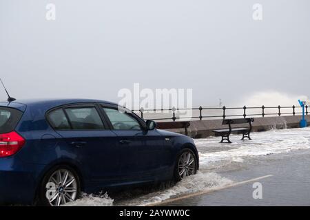 Autos, die auf der überfluteten Promenade in New Brighton Merseyside während des kürzlichen Sturms Ciara fahren. Stockfoto