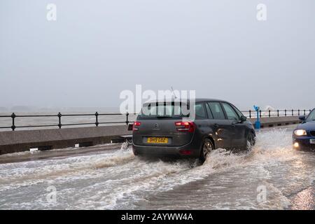 Autos, die auf der überfluteten Promenade in New Brighton Merseyside während des kürzlichen Sturms Ciara fahren. Stockfoto