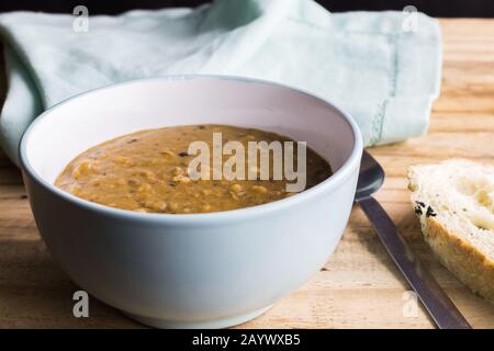 Schüssel mit rustikaler Suppe auf Holztisch Stockfoto