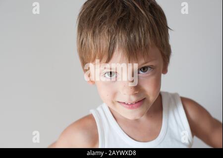 Fröhliches liebenswürdig fröhliches kleines Kind in weißem Tanktop Stockfoto