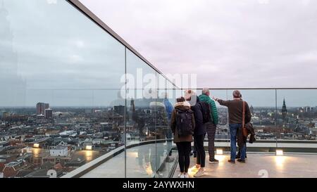 Groningen, Niederlande - 6. Februar 2020: Eine kleine Gruppe kaukasischer Menschen, die einen Blick auf das Dach in der historischen Innenstadt von Groningen genießen. Stockfoto