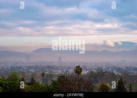 Der Blick über das Becken von Los Angeles auf das Hollywood-Zeichen, während sich Morgennebel mit Wildbrandrauch vermischt, um unerwartete Farben zu erzeugen. Stockfoto