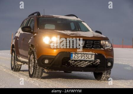 Dacia Duster SUV beim Fahren auf einer verschneiten Straße Stockfoto