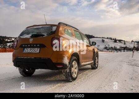 Dacia Duster SUV beim Fahren auf einer verschneiten Straße Stockfoto